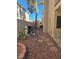 Simple side yard with rock landscaping, stone pavers, and outdoor utilities at 2065 Pinion Springs Dr, Henderson, NV 89074