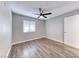 Standard bedroom with a ceiling fan, wood-look floors, and a bright window at 211 Mission Laguna Ln # 205, Las Vegas, NV 89107