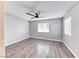 A simple bedroom with gray walls and wood-look flooring, naturally lit by bright windows at 211 Mission Laguna Ln # 205, Las Vegas, NV 89107