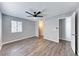 Large primary bedroom featuring neutral walls, wooden floors, a modern ceiling fan and an open doorway at 211 Mission Laguna Ln # 205, Las Vegas, NV 89107