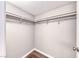 Inside of a simple closet with hanging rods and modern wood-look flooring at 211 Mission Laguna Ln # 205, Las Vegas, NV 89107