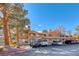 Attractive condo complex featuring stucco exteriors, terracotta roofs, balconies, covered parking, and mature shade trees at 211 Mission Laguna Ln # 205, Las Vegas, NV 89107