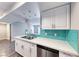 The kitchen features stainless steel appliances, white cabinets, light countertops, and a tiled backsplash at 211 Mission Laguna Ln # 205, Las Vegas, NV 89107