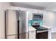 This kitchen includes stainless steel appliances, white cabinetry and a stylish teal backsplash at 211 Mission Laguna Ln # 205, Las Vegas, NV 89107