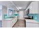 This modern kitchen features stainless steel appliances, white cabinets, quartz countertops, and a teal backsplash at 211 Mission Laguna Ln # 205, Las Vegas, NV 89107