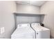 Convenient laundry area with a washer, dryer, and a shelf for storing supplies at 211 Mission Laguna Ln # 205, Las Vegas, NV 89107