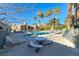 Community pool with nearby palm trees, lounge chairs, and a picnic table at 211 Mission Laguna Ln # 205, Las Vegas, NV 89107