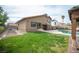 Expansive backyard featuring a well-maintained lawn, refreshing pool, and covered patio area at 220 Hollyfern St, Henderson, NV 89074