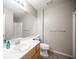 Well-lit bathroom with a single sink vanity, toilet, and a glass-enclosed shower at 220 Hollyfern St, Henderson, NV 89074
