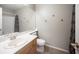 Bathroom features a vanity, toilet, mirror and cabinet, accented by a decorative shower curtain at 220 Hollyfern St, Henderson, NV 89074