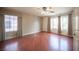 Spacious bedroom with hardwood floors, ceiling fan, and natural light from multiple windows at 220 Hollyfern St, Henderson, NV 89074