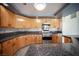 Well-lit kitchen featuring wood cabinets, stainless steel appliances, and granite countertops at 220 Hollyfern St, Henderson, NV 89074