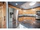 Close up of updated kitchen featuring stainless steel appliances, granite countertops, and custom wood door to the pantry at 220 Hollyfern St, Henderson, NV 89074