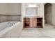 Elegant bathroom featuring a soaking tub, vanity with storage, and a separate tiled shower at 24 Via Vasari # 104, Henderson, NV 89011