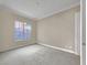 Bedroom with neutral carpeting, baseboard trim, window, and view of the door on the right at 24 Via Vasari # 104, Henderson, NV 89011