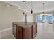 Open-concept living room with tile flooring, island, and access to a balcony with scenic views at 24 Via Vasari # 104, Henderson, NV 89011