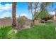 Landscaped backyard featuring grass, rock features, and mature trees at 2424 Chestnut Hill St, Las Vegas, NV 89134