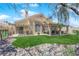 Spacious backyard with manicured lawn, rock features, covered patio, and desert landscaping at 2424 Chestnut Hill St, Las Vegas, NV 89134