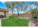 Beautifully landscaped backyard with lush grass, rock features, and mature trees at 2424 Chestnut Hill St, Las Vegas, NV 89134