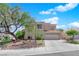Two-story home with a two car garage, desert landscaping, mature trees and a tile roof at 2424 Chestnut Hill St, Las Vegas, NV 89134