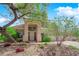Home exterior showcasing a well-manicured lawn, mature trees, and a charming covered entryway at 2424 Chestnut Hill St, Las Vegas, NV 89134