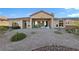 Rear exterior of a tan house with an open patio and rock landscaping at 2548 Faiss Dr, Las Vegas, NV 89134
