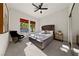 Sunlit bedroom with a stylish ceiling fan and tufted headboard offers comfort and a peaceful ambiance at 2548 Faiss Dr, Las Vegas, NV 89134