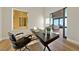 Bright office features modern desk setup with exterior window and a glimpse of the living area at 2548 Faiss Dr, Las Vegas, NV 89134