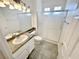Bathroom featuring a granite countertop, dual sinks, and a glass-enclosed shower at 2558 Grandville Ave, Henderson, NV 89052