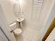 Powder room features pedestal sink, toilet, tile floor and shuttered window for natural light at 2558 Grandville Ave, Henderson, NV 89052
