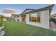 Manicured backyard featuring artificial turf, landscaping, and patio at 26 Sun Mirage Ave, Henderson, NV 89011