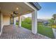 Outdoor patio with ceiling fans transitions to green lawn, landscaping, and mountain views at 26 Sun Mirage Ave, Henderson, NV 89011