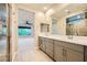 Bathroom with double vanity, mirrors, and marble tile shower at 26 Sun Mirage Ave, Henderson, NV 89011