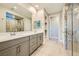 Well-lit bathroom featuring double sinks, spacious counter, tile floors, and a glass-enclosed shower at 26 Sun Mirage Ave, Henderson, NV 89011