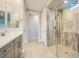 Modern bathroom with a walk-in shower featuring marble tile, and a double vanity at 26 Sun Mirage Ave, Henderson, NV 89011