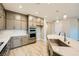 Modern kitchen features gray cabinetry, stainless steel appliances, and a spacious island with marble countertop at 26 Sun Mirage Ave, Henderson, NV 89011