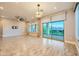 Open-concept living area with wood-look tile, modern fan and sliding glass doors to outdoor patio at 26 Sun Mirage Ave, Henderson, NV 89011