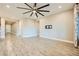Spacious living room featuring wood-look tile flooring and modern ceiling fan with multiple lights at 26 Sun Mirage Ave, Henderson, NV 89011