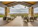 Inviting outdoor lounge area with stone pillars, wood ceilings, and comfortable seating at 26 Sun Mirage Ave, Henderson, NV 89011