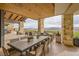 Expansive outdoor patio with stone pillars, wood ceilings, lounge areas, and dining tables at 26 Sun Mirage Ave, Henderson, NV 89011