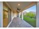 Covered patio with ceiling fans, brick floor, and a view of the landscaped backyard with mountains in the background at 26 Sun Mirage Ave, Henderson, NV 89011