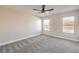 Bright bedroom features neutral walls, carpet flooring, a ceiling fan, and two windows at 2629 Blue Reef Dr, North Las Vegas, NV 89032