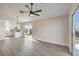 Bright living room with sliding glass doors, wood-look flooring, and an open layout to the kitchen at 2629 Blue Reef Dr, North Las Vegas, NV 89032