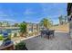 Covered back patio with dining table, stone pillars, water view and access to the canal at 2708 Port Of Call Dr, Las Vegas, NV 89128