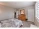 Cozy bedroom features a patterned comforter and a wooden dresser with a decorative mirror at 2711 Evolutionary Ln, Las Vegas, NV 89138