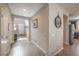 Bright hallway featuring hardwood floors and neutral paint leading to the kitchen and living spaces at 2711 Evolutionary Ln, Las Vegas, NV 89138