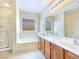 Bright bathroom features double sinks, large mirror, soaking tub and separate shower at 2713 Rue Toulouse Ave, Henderson, NV 89044