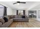 Inviting living room with wood floors, modern ceiling fan, and an open view into the kitchen at 2724 Spear St, North Las Vegas, NV 89030