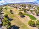 Scenic aerial view of lush golf course landscape and residential homes, backed by a majestic mountain range at 2740 Billy Casper Dr, Las Vegas, NV 89134