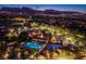 Scenic aerial view of a community clubhouse with pool, manicured grounds, and mountain views at dusk at 2740 Billy Casper Dr, Las Vegas, NV 89134
